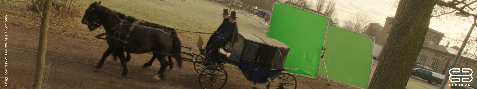 Film set with horse-drawn carriage in front of a green screen