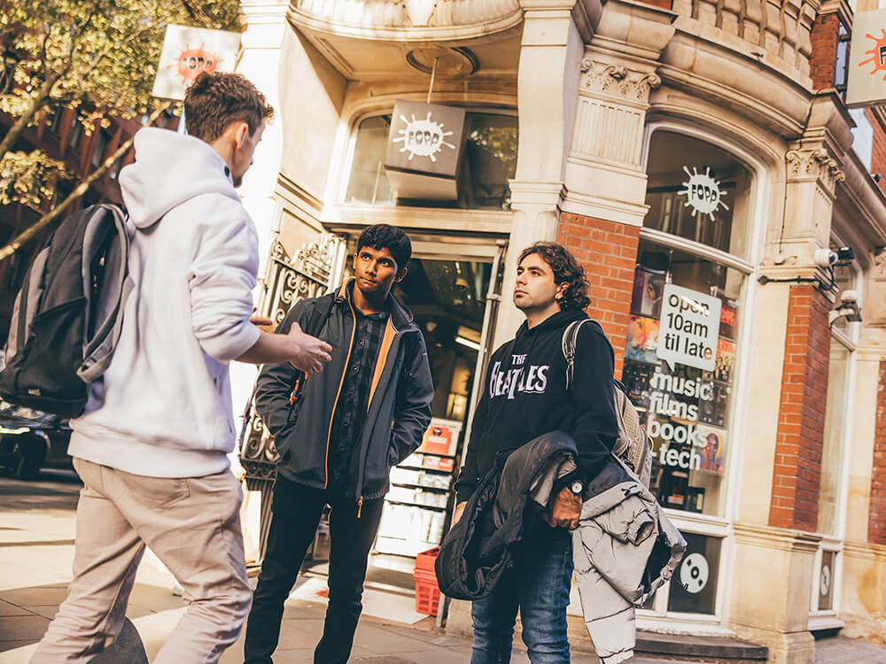 Three students chatting in front of a shop
