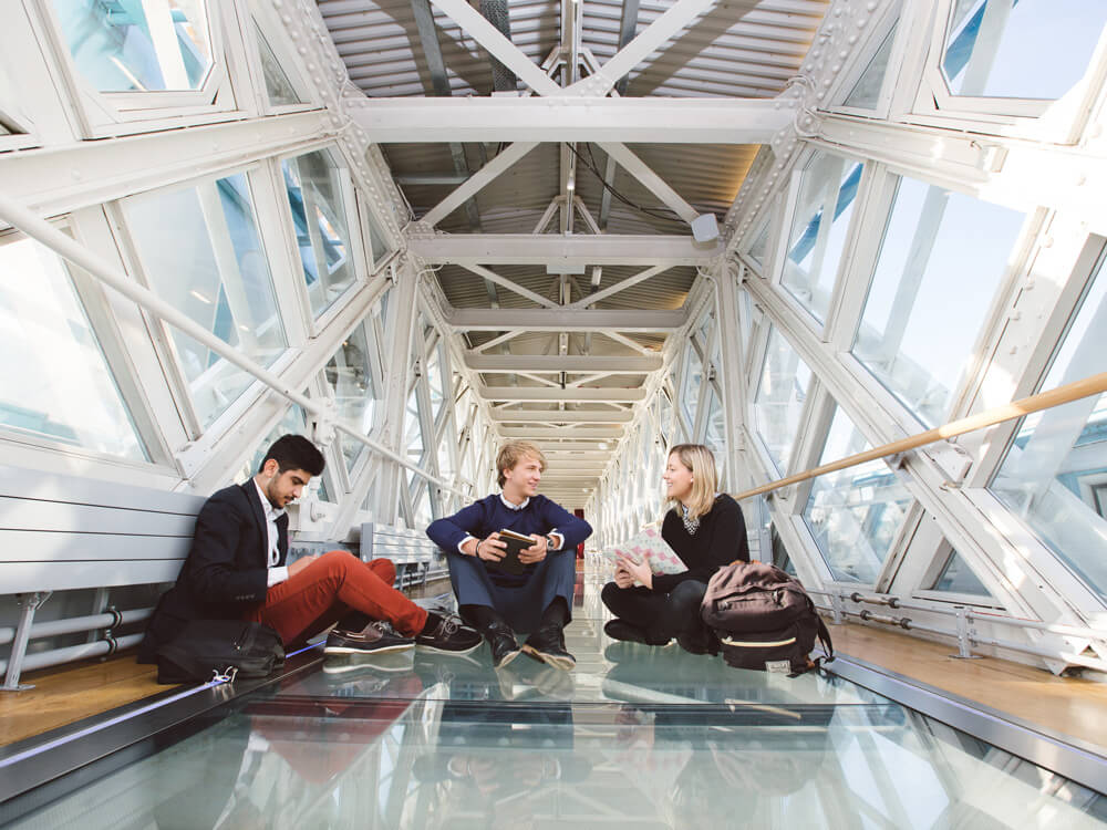 Students sitting on glass bridge 
