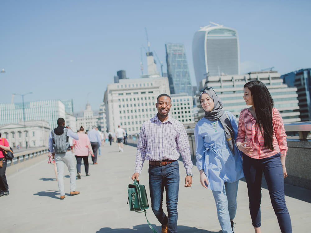 Students walking with London City buildings in background