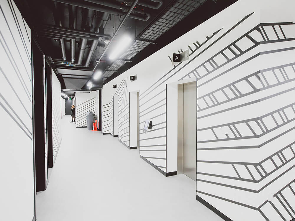 A black and white decorated corridor with lifts