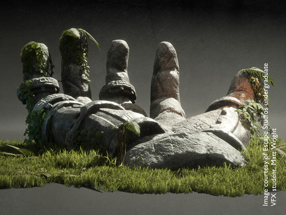 A grey hand made out of rock positioned on green grass
