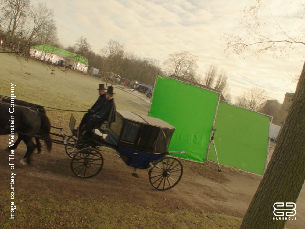 Film set with horse-drawn carriage in front of a green screen